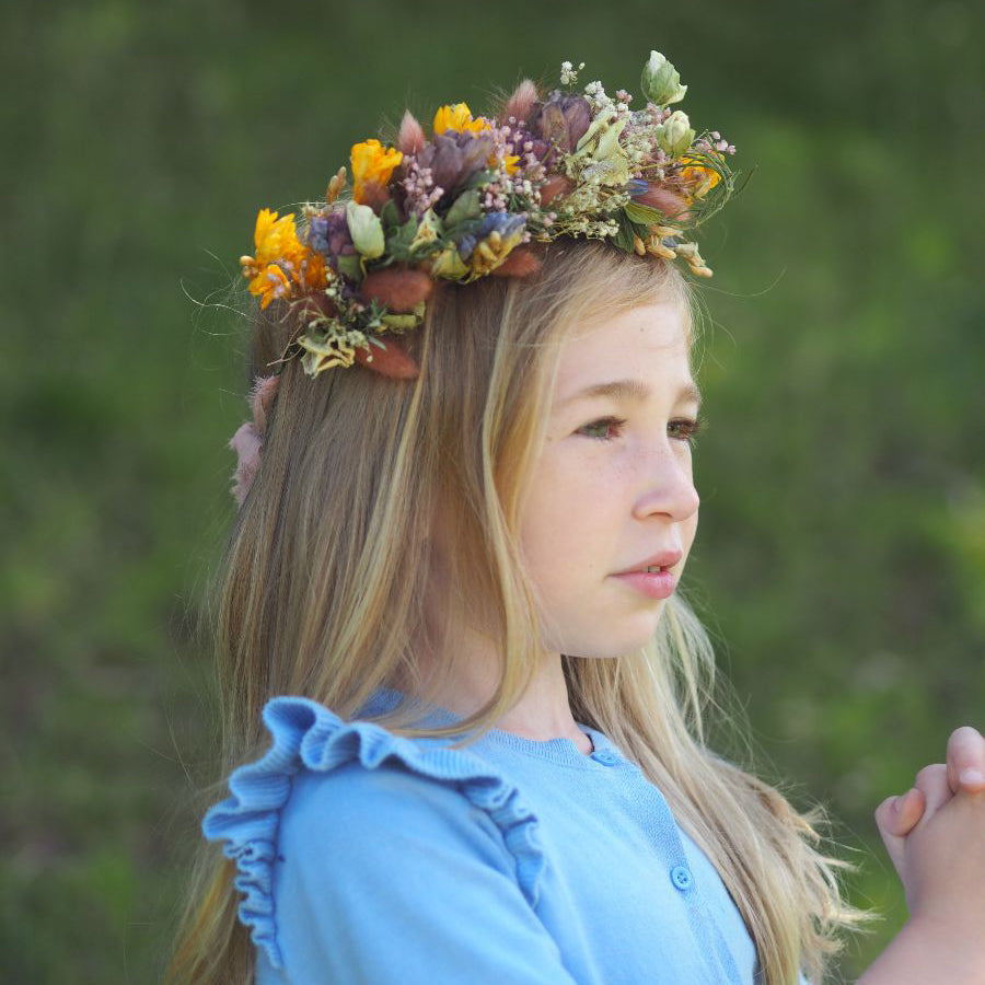 A girl wearing a beautiful crown made with fresh flowers